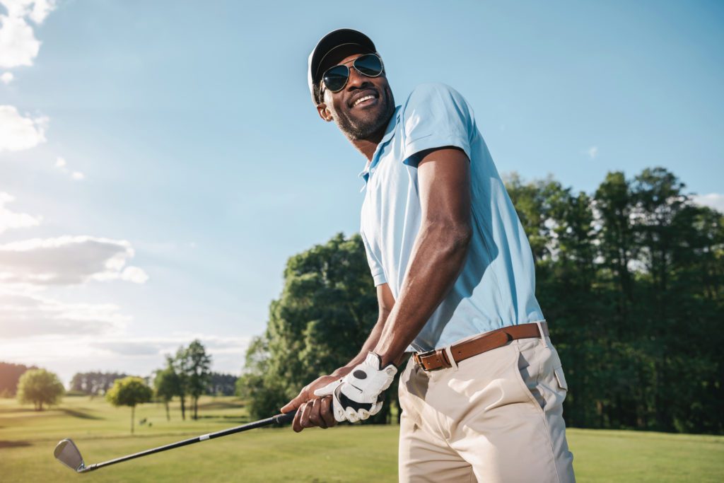 Smiling african american man playing golf